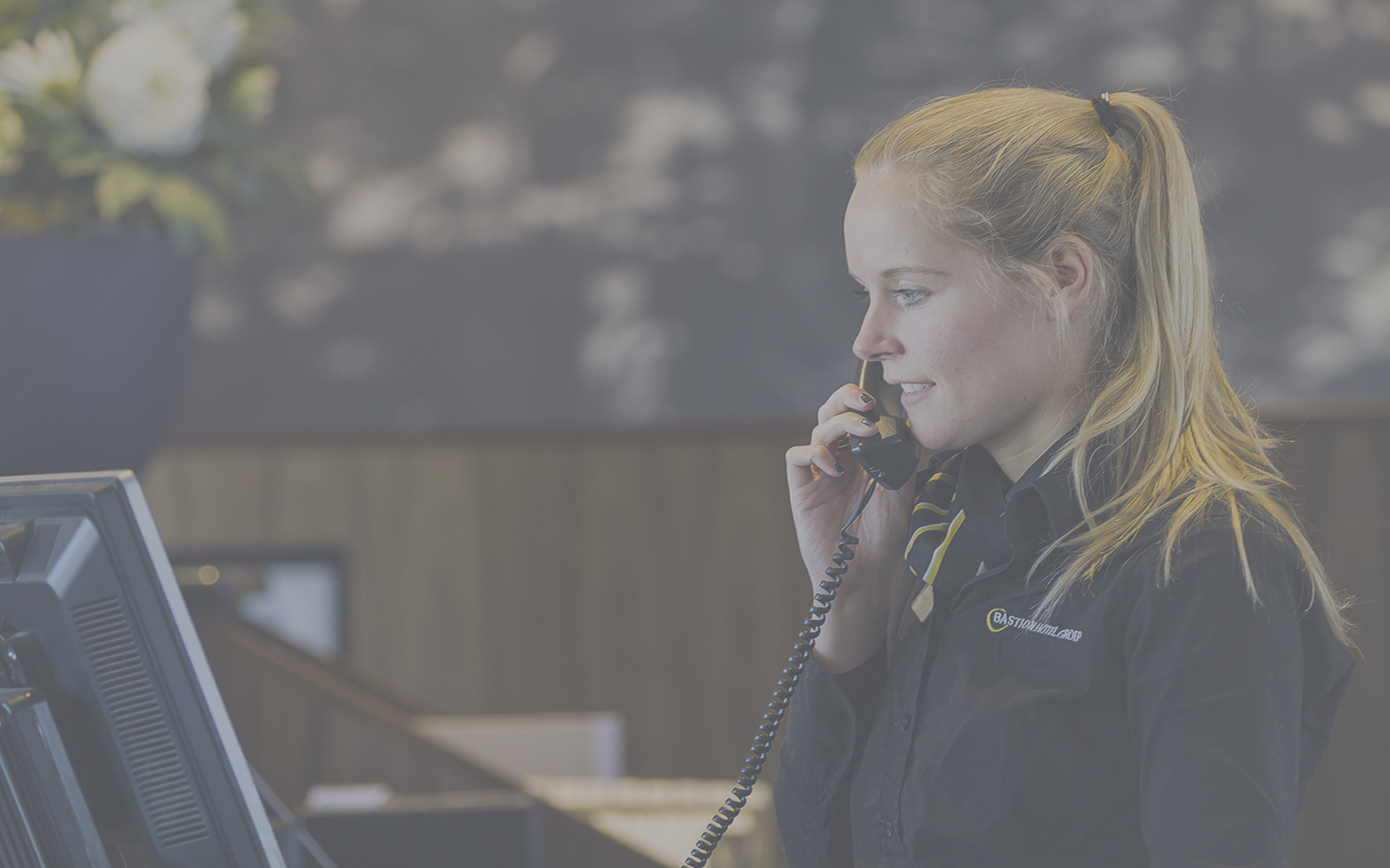 Receptiemedewerker van Bastion aan de telefoon