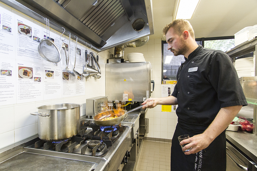 Kok bereidt een gerecht in een Bastion-keuken